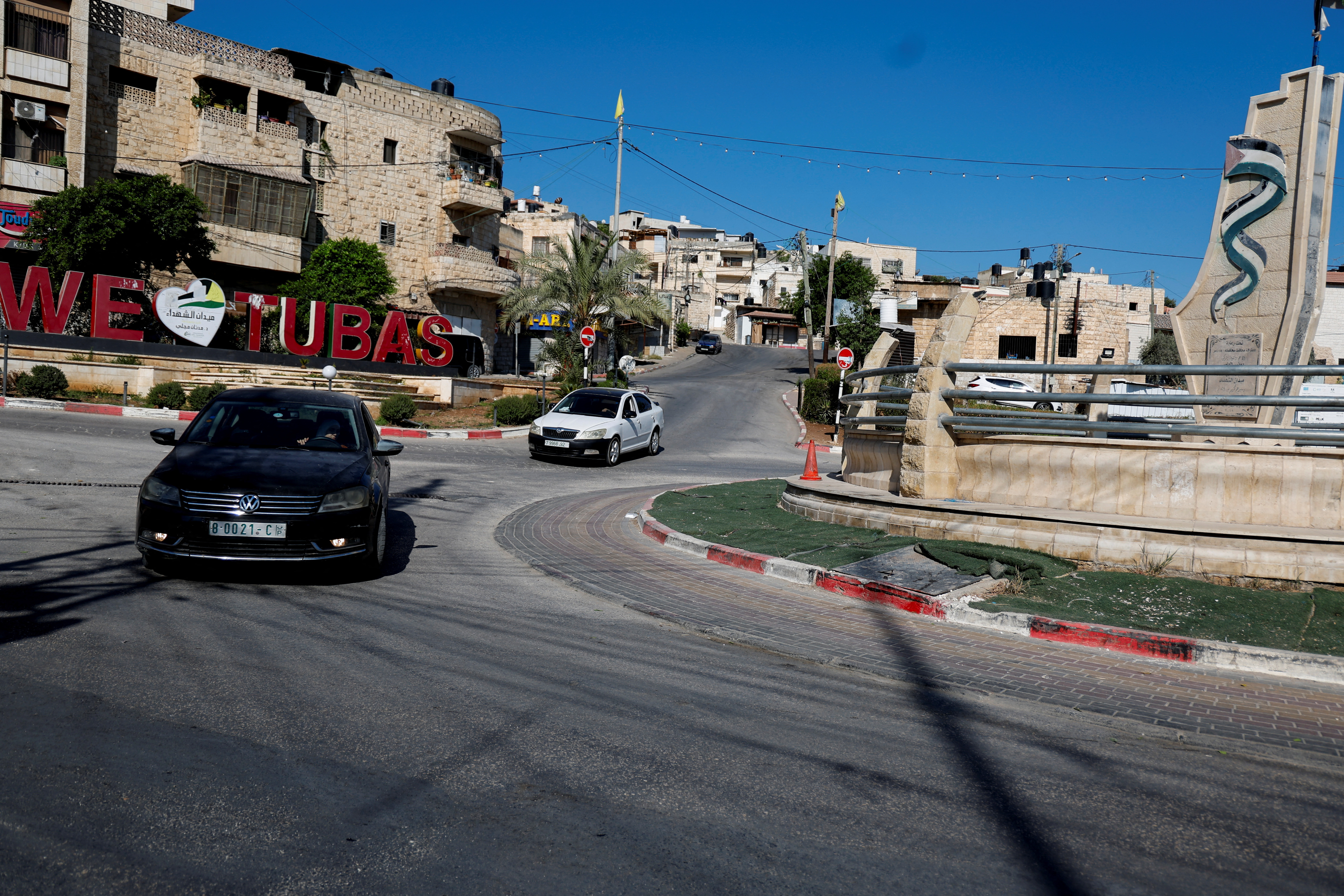 Palestinians drive by signage that reads "We heart Tubas" during a general strike after the assassination of Hamas leader Ismail Haniyeh in Iran, in Tubas