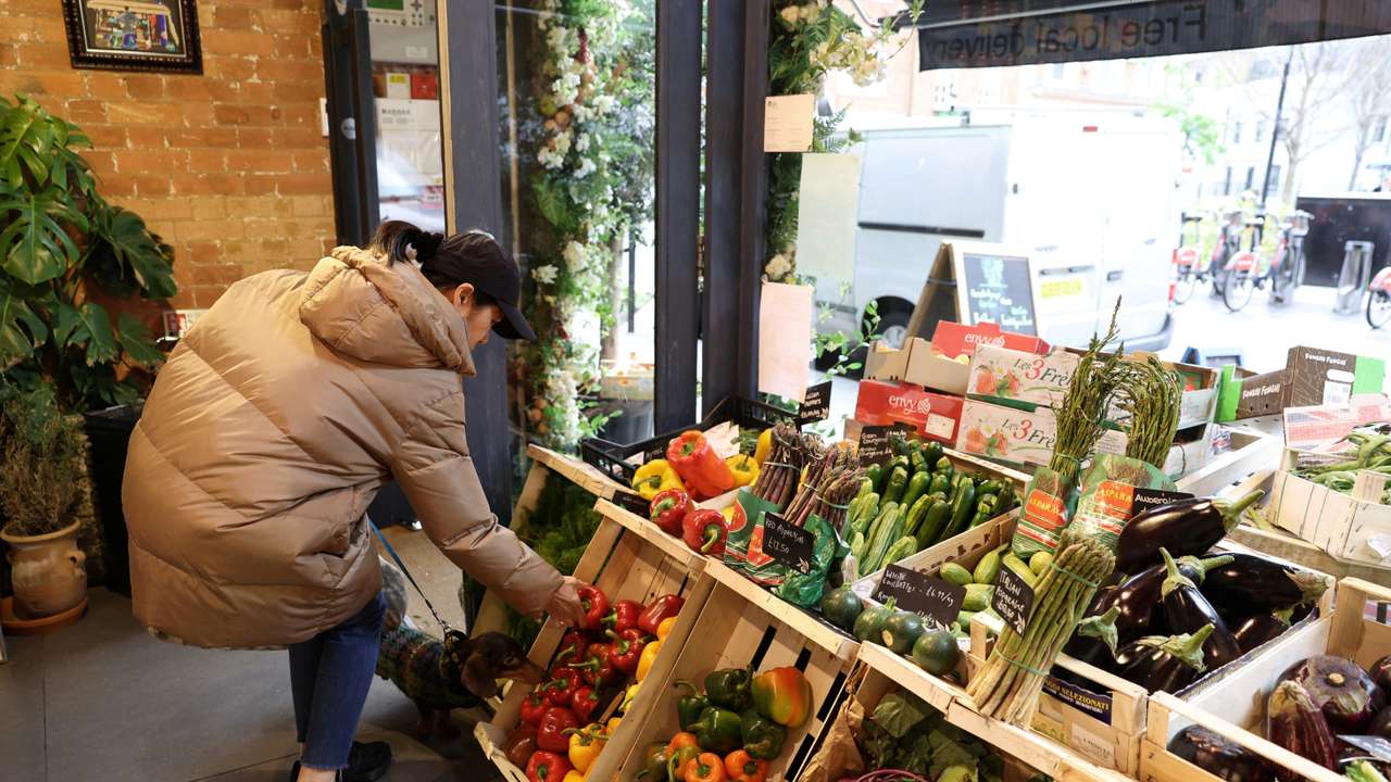 A customer shops for vegetables at gourmet grocery store Andreas, in London