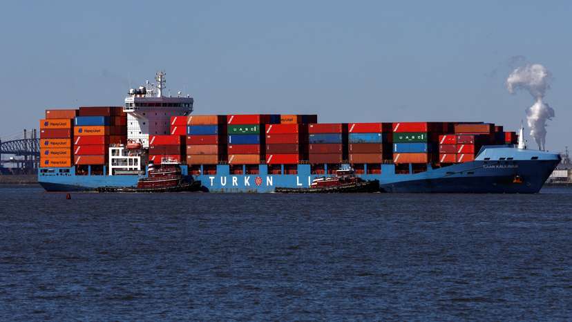 A cargo ship is brought into the Port of Elizabeth marine terminal seen from Bayonne, New Jersey