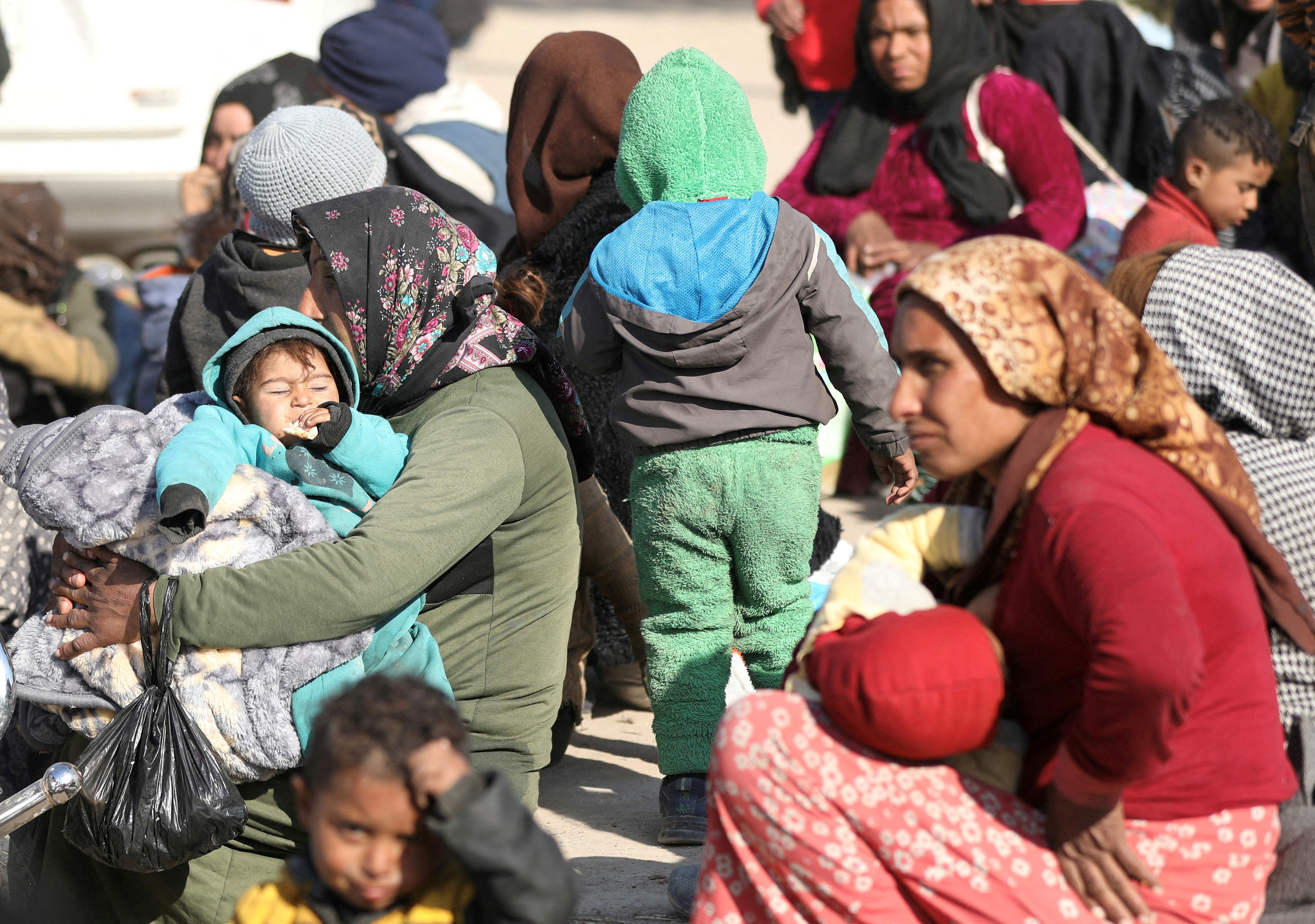 FILE PHOTO: Displaced women who fled Aleppo countryside, sit with their children in Tabqa,