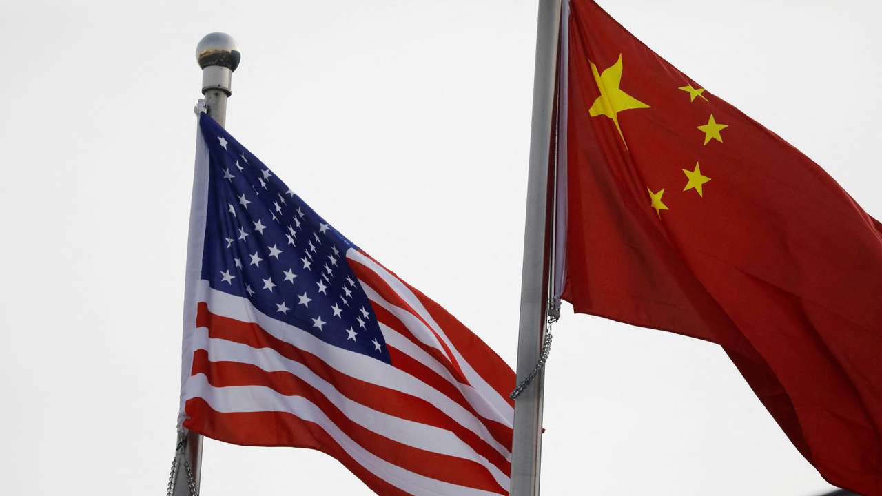 FILE PHOTO: Chinese and U.S. flags flutter outside the building of an American company in Beijing