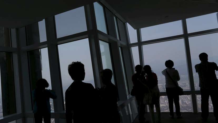 Tourists take photos of the city skyline from the Taipei 101 skyscraper building in Taipei, Taiwan