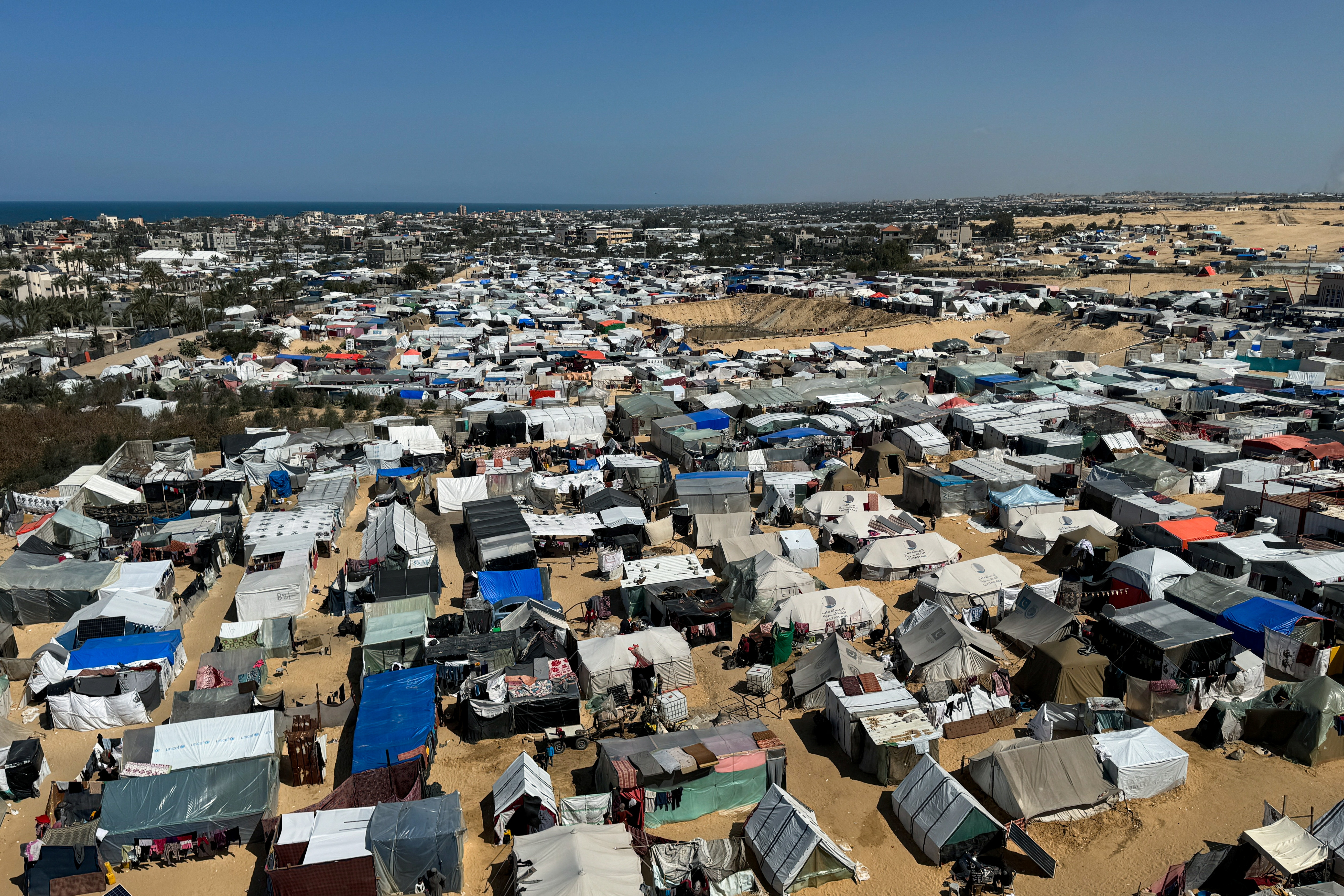 Displaced Palestinians, who fled their houses due to Israeli strikes, shelter in a tent camp, in Rafah