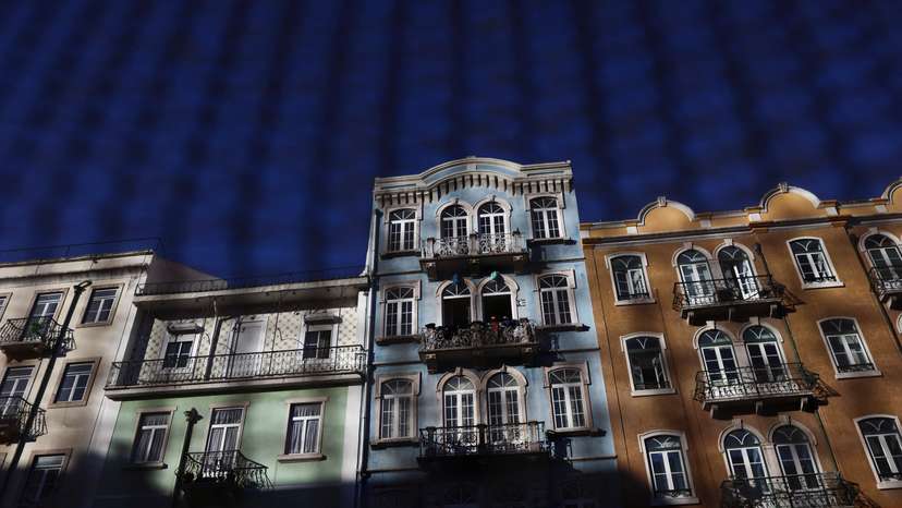 Residential buildings are seen through a fence in Lisbon