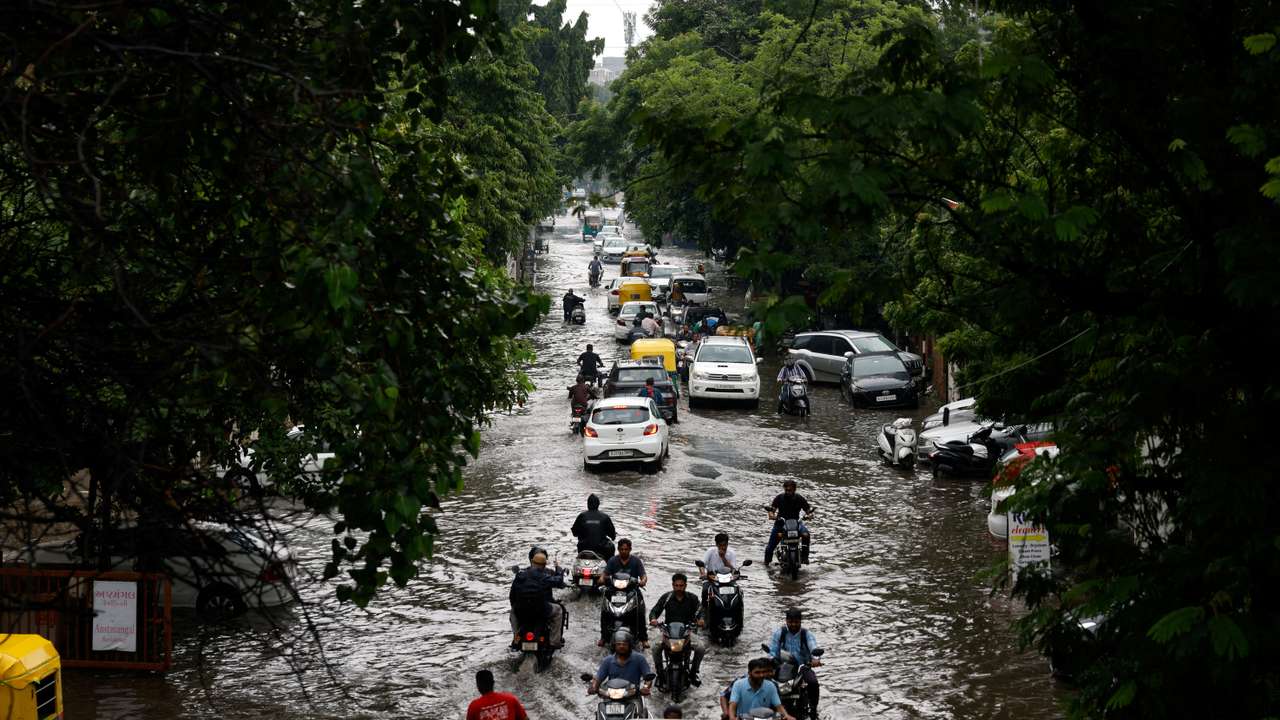 FILE PHOTO: Traffic moves through a flooded road after heavy rains in Ahmedabad