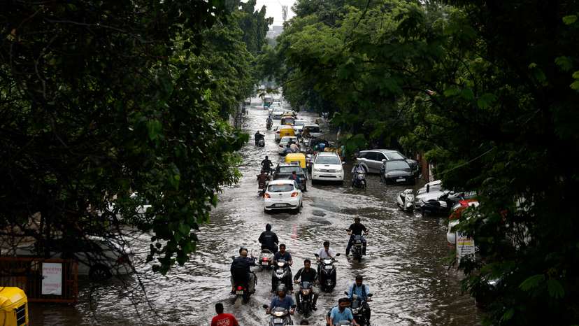 FILE PHOTO: Traffic moves through a flooded road after heavy rains in Ahmedabad