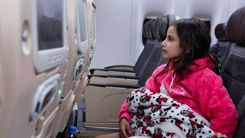 Qamar Shureihy, 10, a Palestinian girl from Gaza who was wounded during the ongoing conflict between Israel and the Palestinian Islamist group Hamas, sits in a plane to the United Arab Emirates to receive medical care, in Al Arish