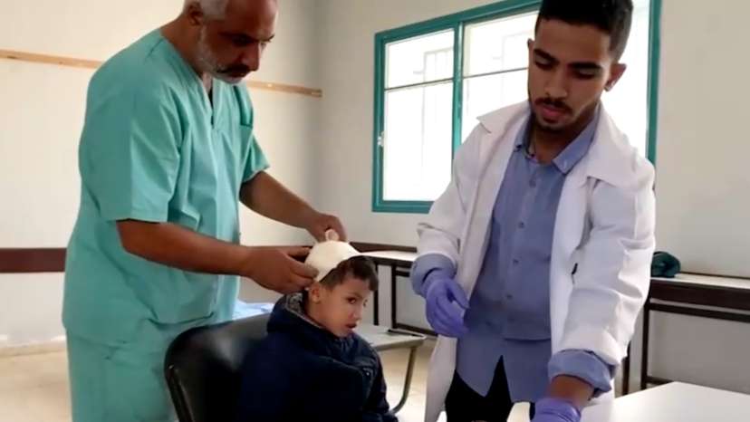 Doctors attend to a patient at a field clinic inside a central Gaza school in Deir Al-Balah, in this screengrab taken from a video.