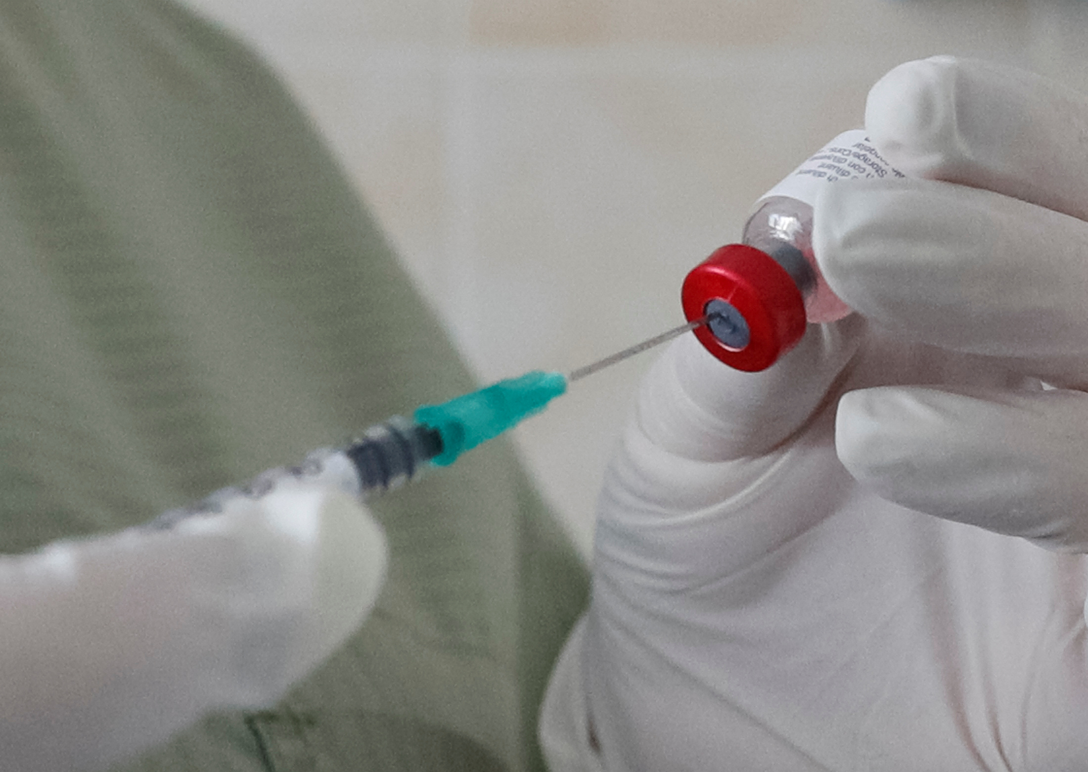 A nurse fills a syringe with a vaccine before administering an injection at a kids clinic in Kiev