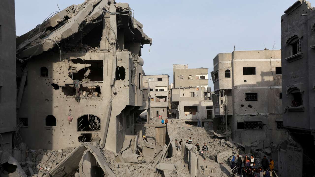 Palestinians inspect damage at the site of an Israeli strike on a house, at Nuseirat refugee camp