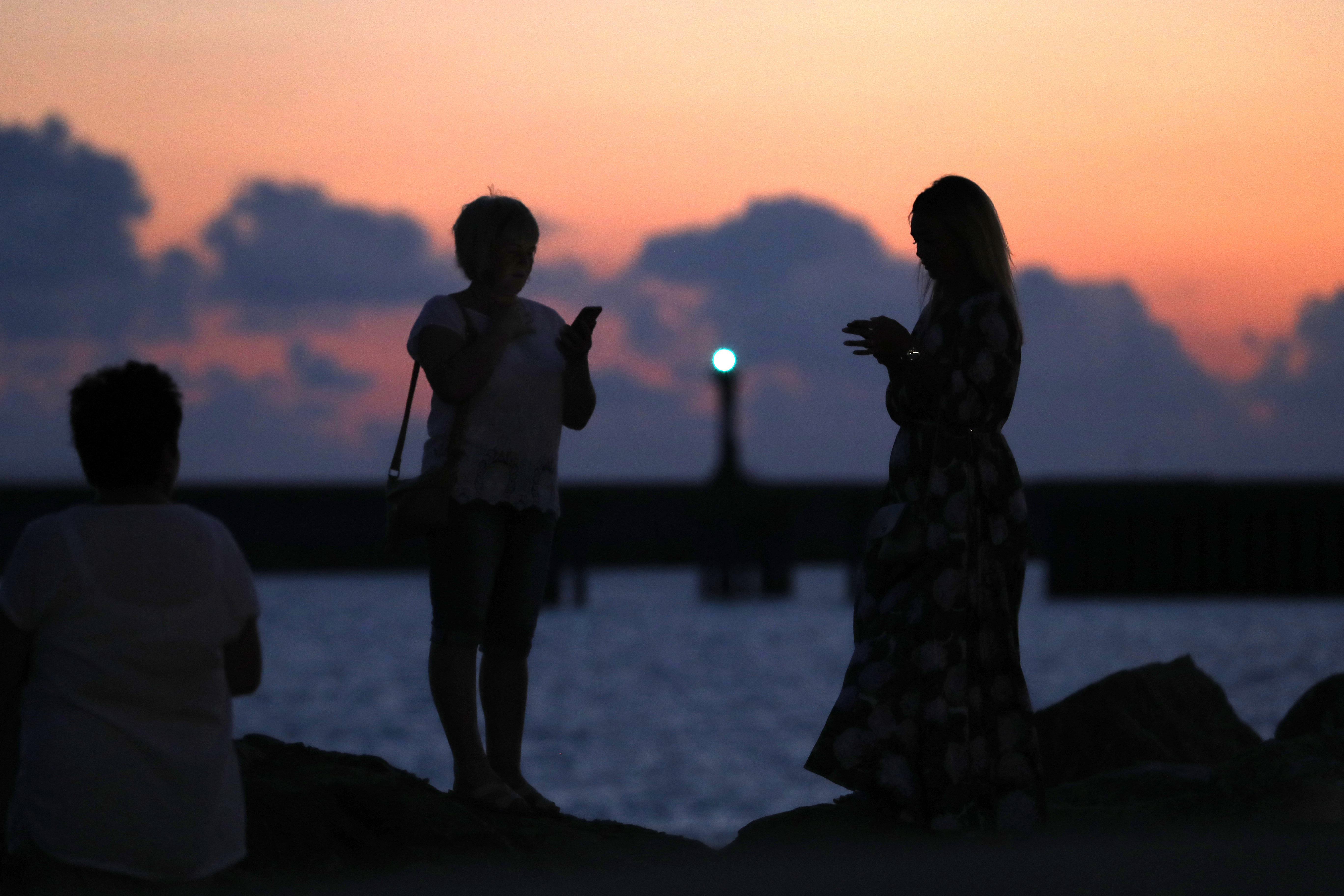 Women look on near the port in Sochi