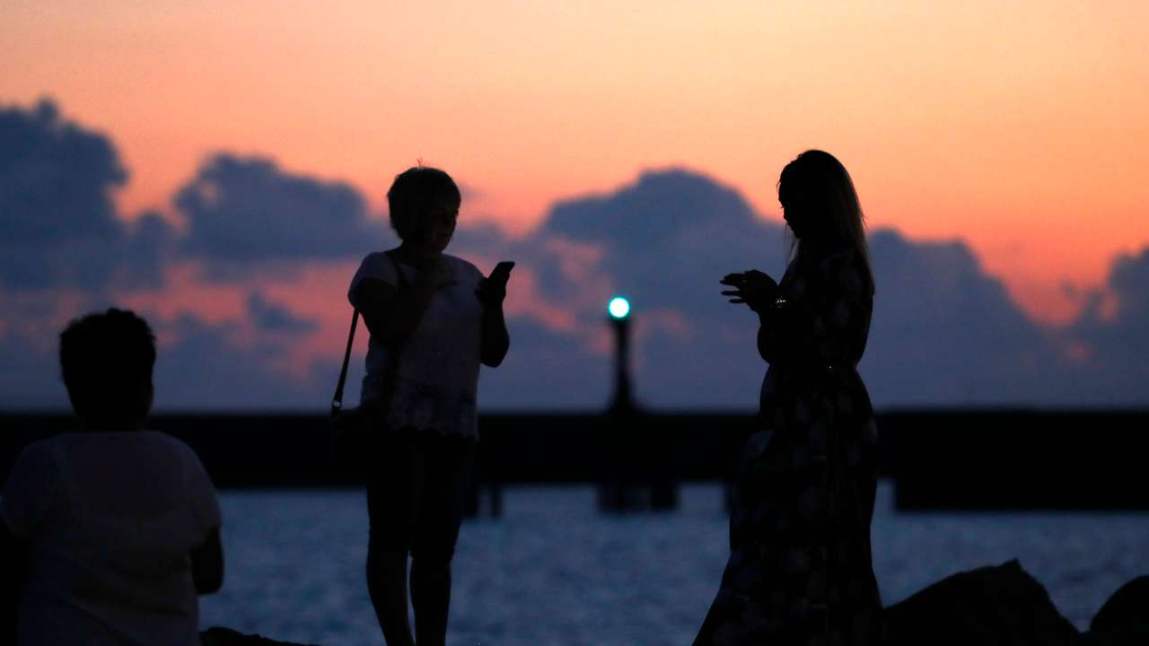 Women look on near the port in Sochi