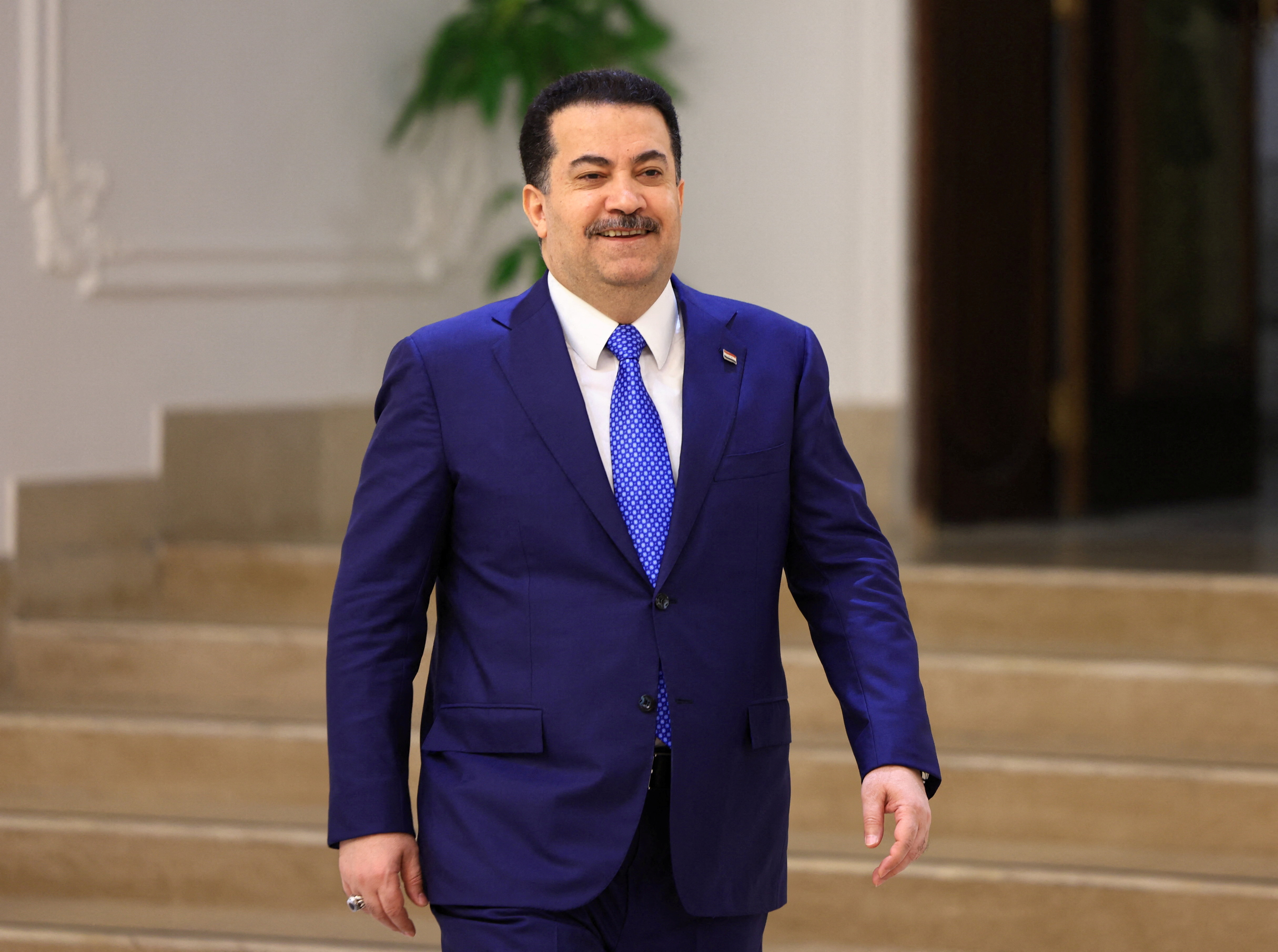 Iraqi Prime Minister Mohammed Shia al-Sudani walks before an interview with Reuters in Baghdad