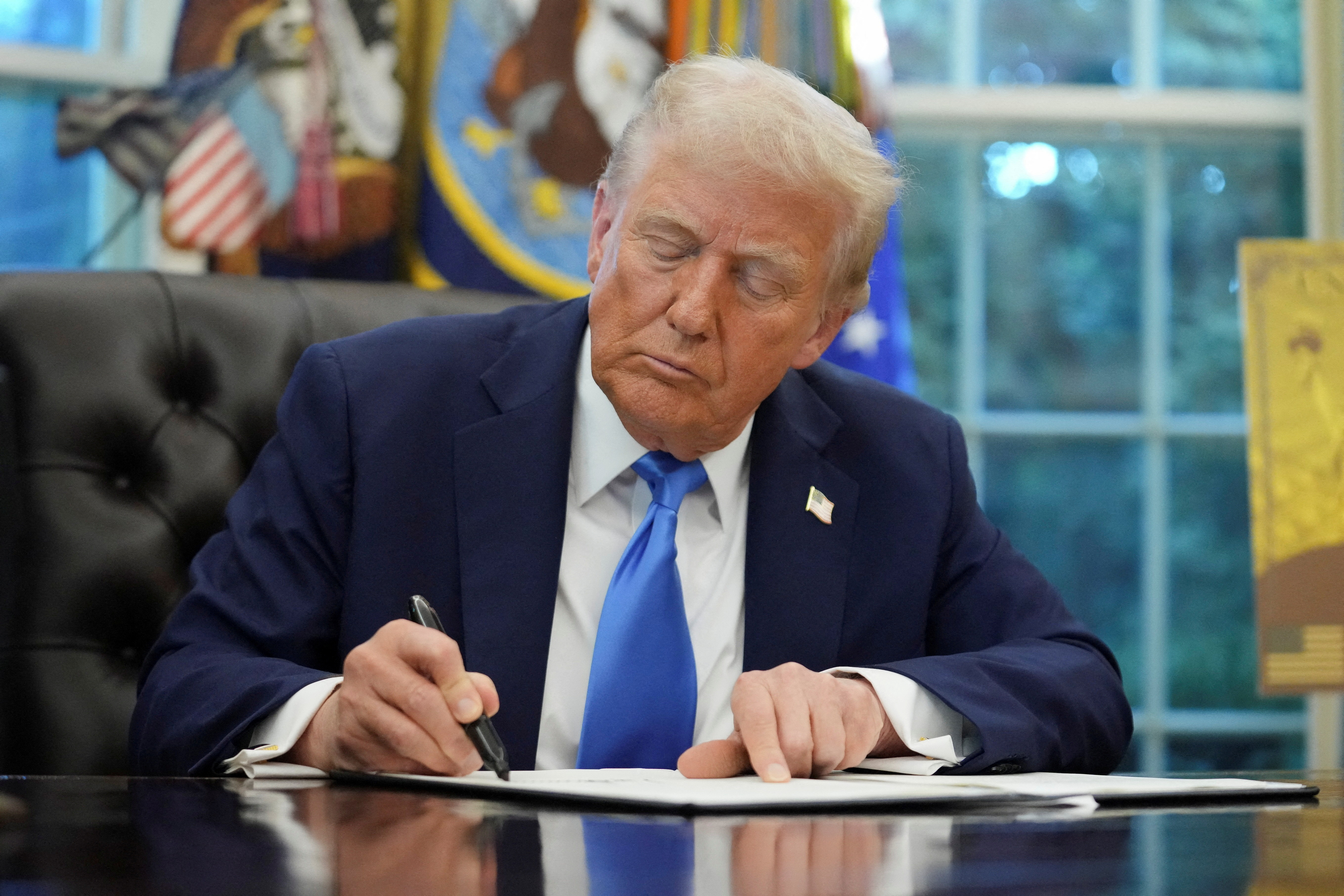 FILE PHOTO: U.S. President Donald Trump signs executive orders in the Oval Office at the White House in Washington