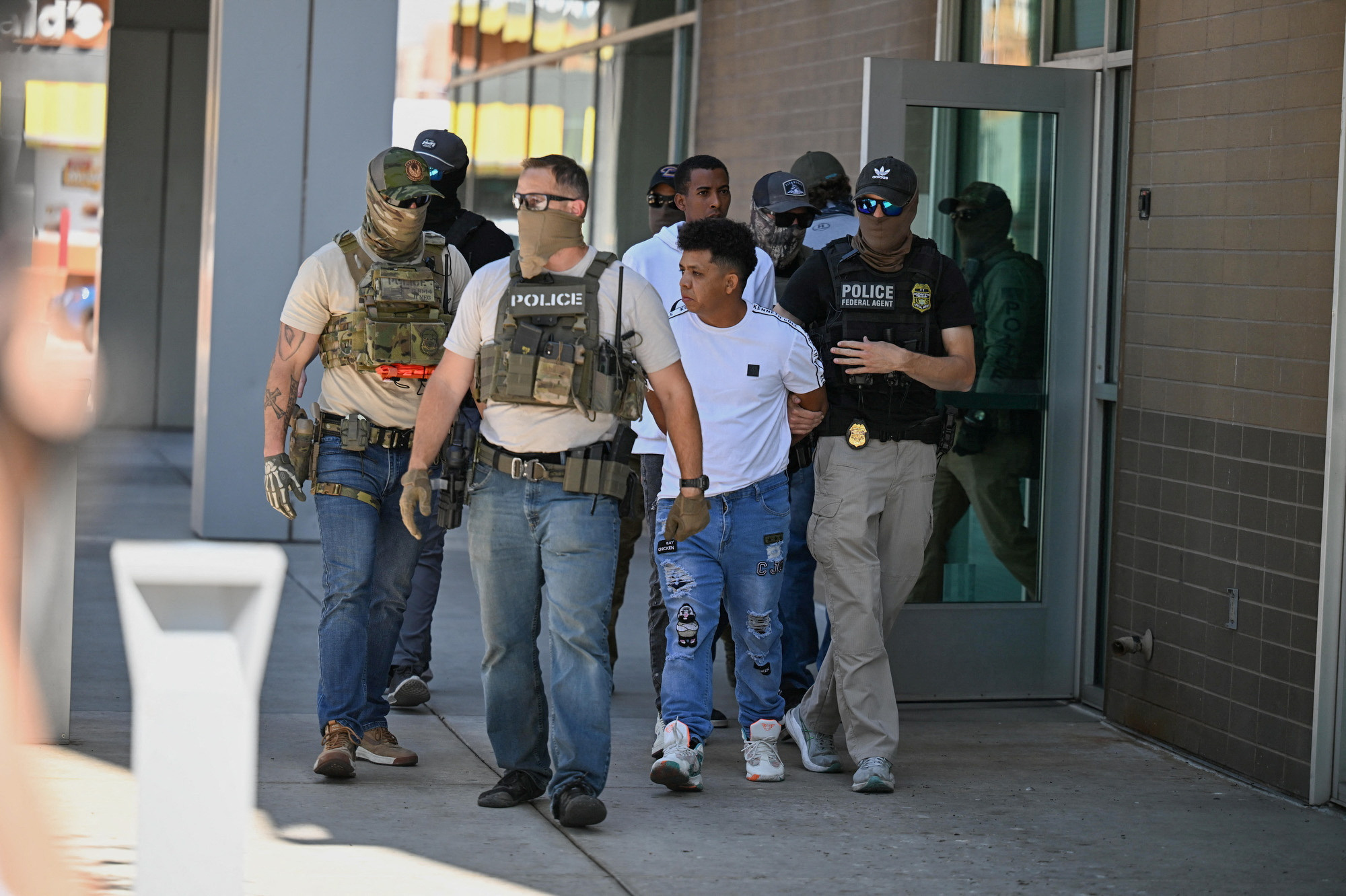 Law enforcement officers, including HSI and ICE agents, take people into custody at an immigration court in Phoenix
