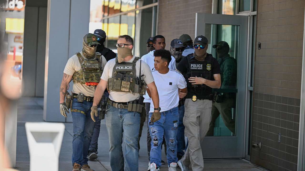 Law enforcement officers, including HSI and ICE agents, take people into custody at an immigration court in Phoenix