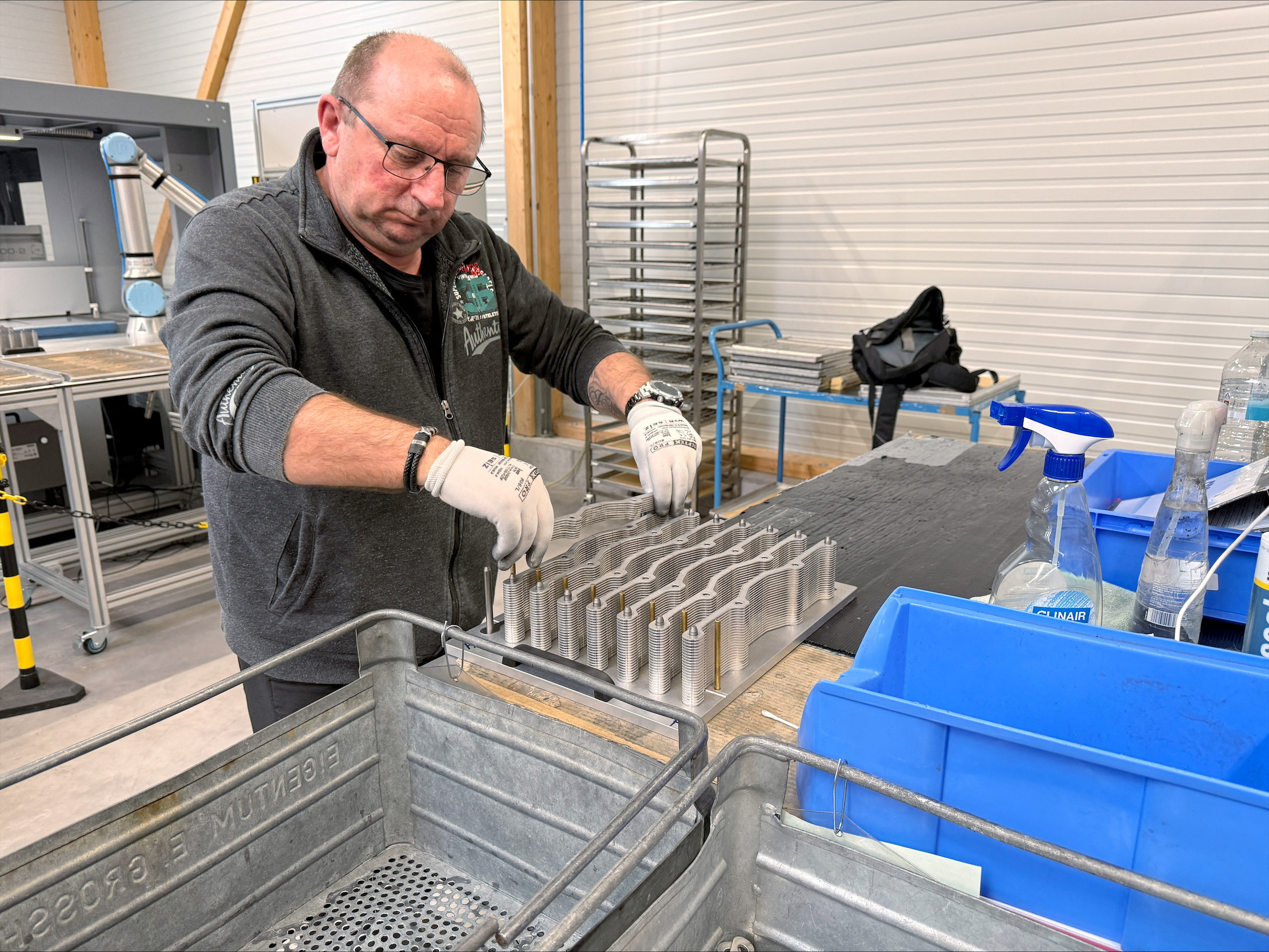 A worker operates machinery at the production facility of Dostech GmbH in Moessingen