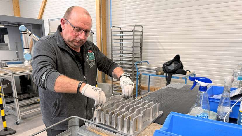 A worker operates machinery at the production facility of Dostech GmbH in Moessingen