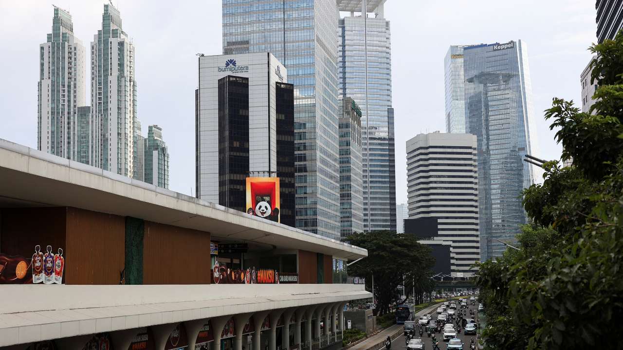 Vehicles drive past Jakarta’s business district