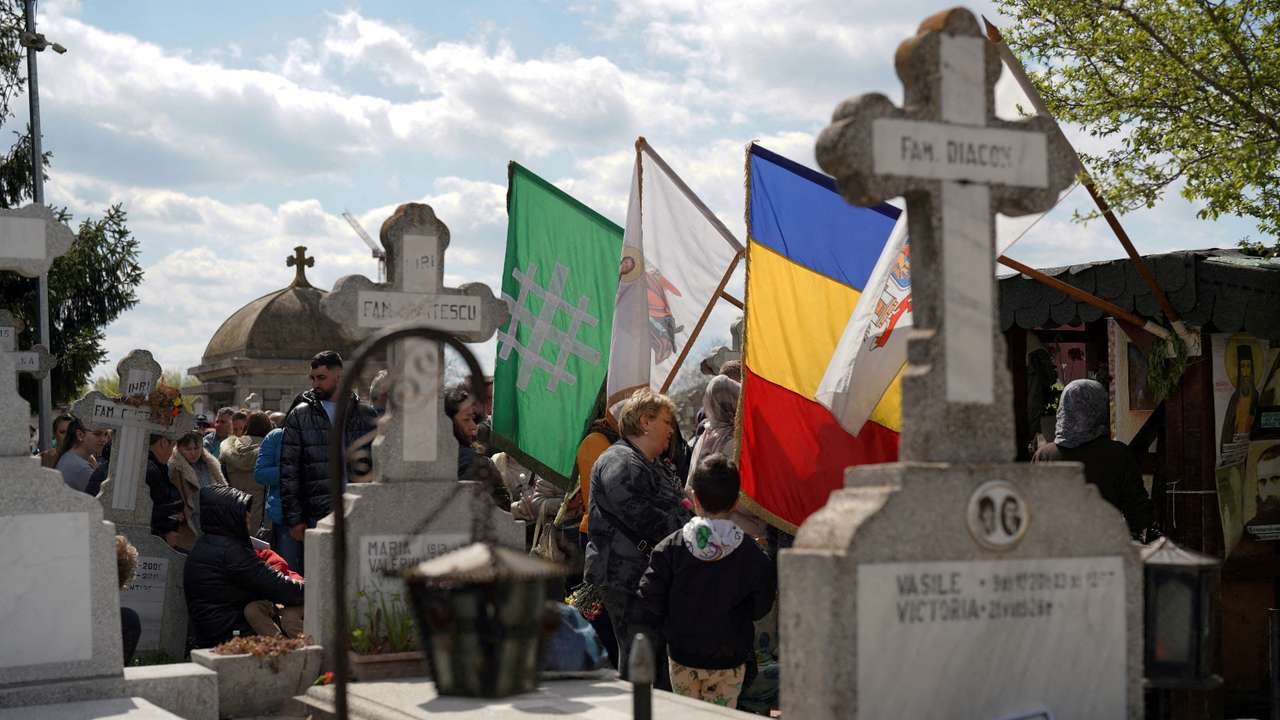 FILE PHOTO: People queue up at a tomb bearing the flag with the insignia of the Iron Guard, in Bucharest