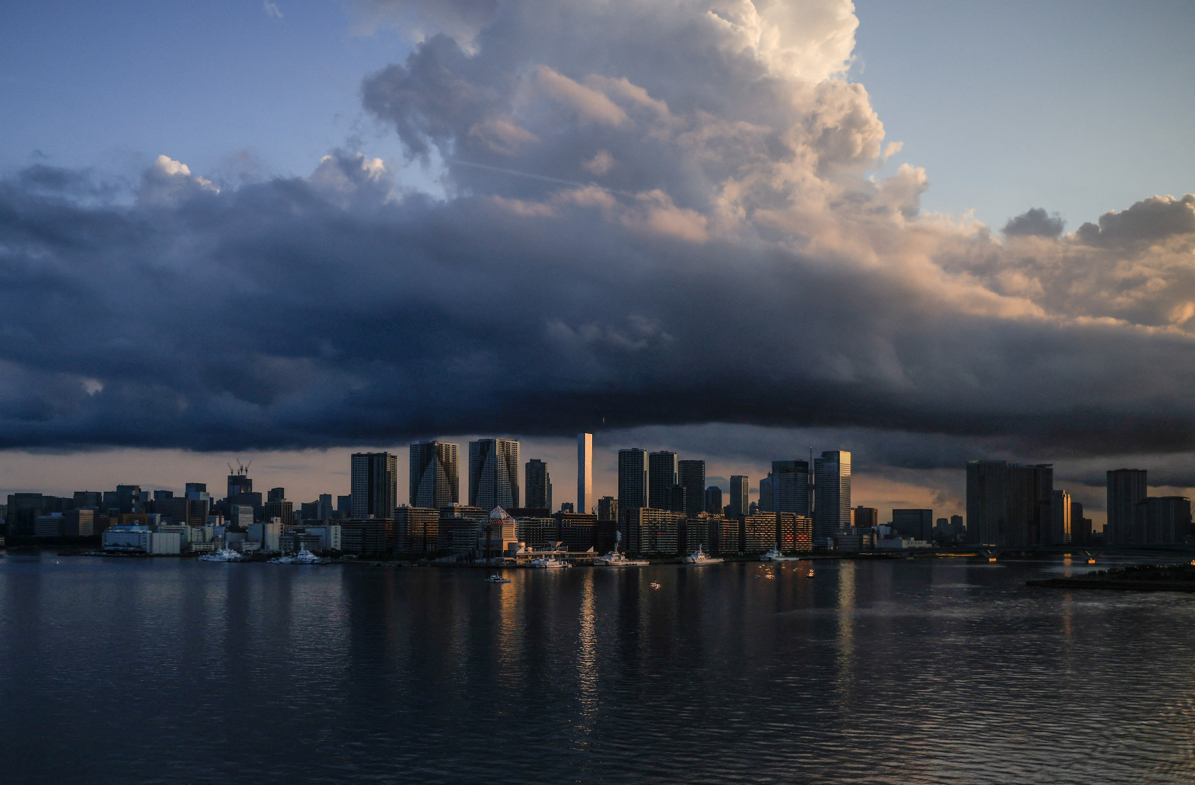 FILE PHOTO: City skyline and harbour are seen at sunrise from a quarantine bus window during the Tokyo 2020 Olympic Games in Tokyo, Japan