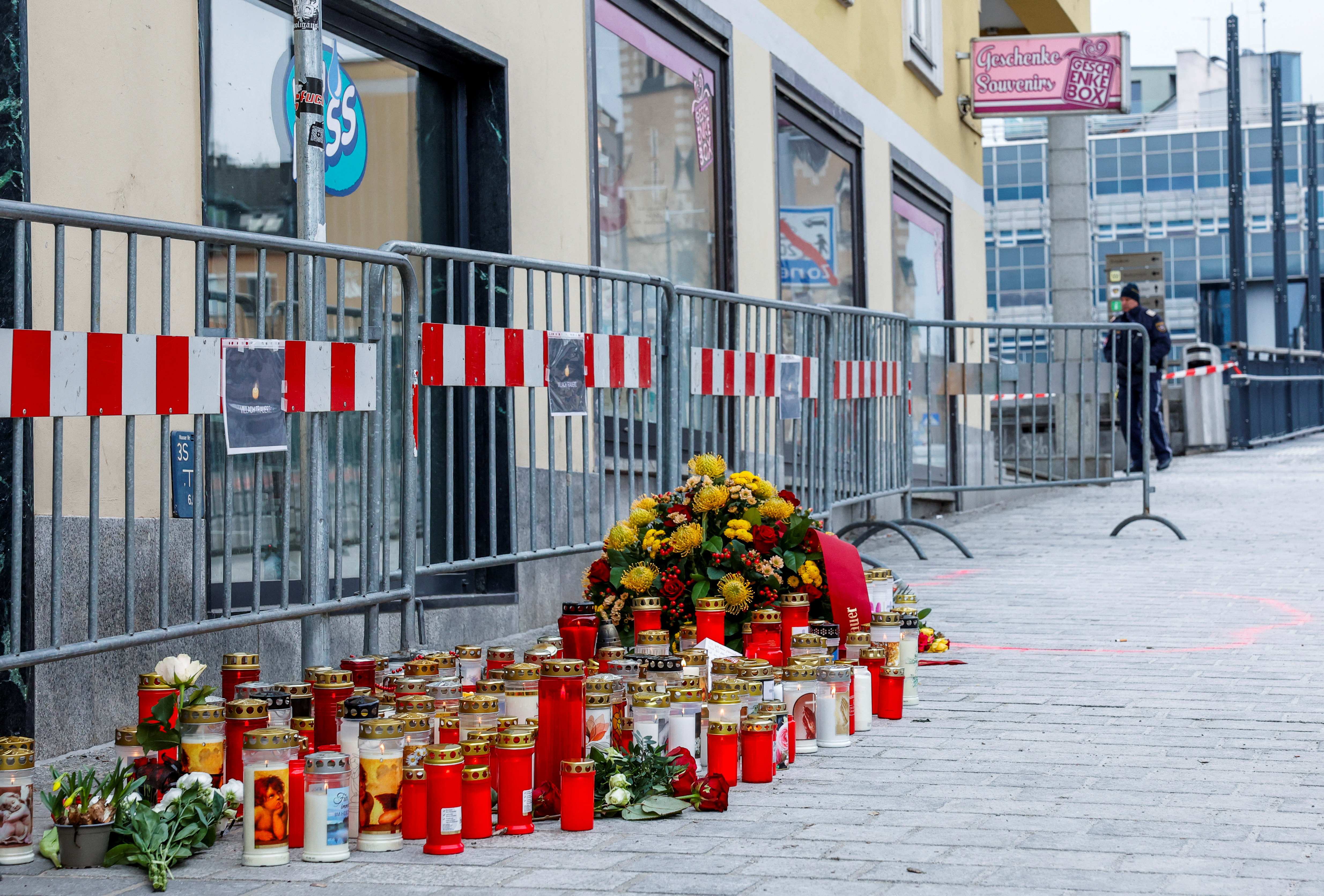 Candles and flowers sit at the scene where a 14-year-old boy was killed and several others were wounded in a stabbing attack, in the town of Villach