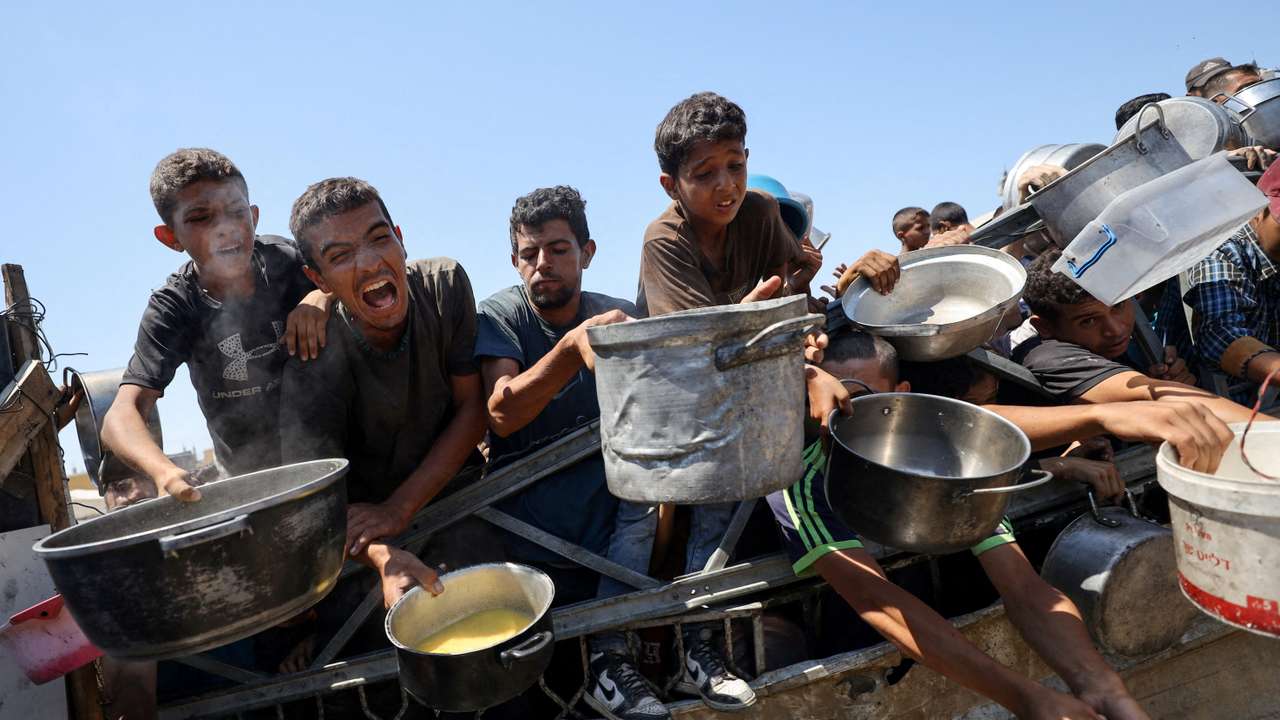 Palestinians receive food from charity kitchen, in Gaza City