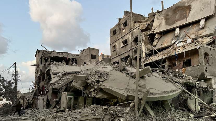 Palestinians walk at the site of Israeli strikes on houses, in Jabalia refugee camp