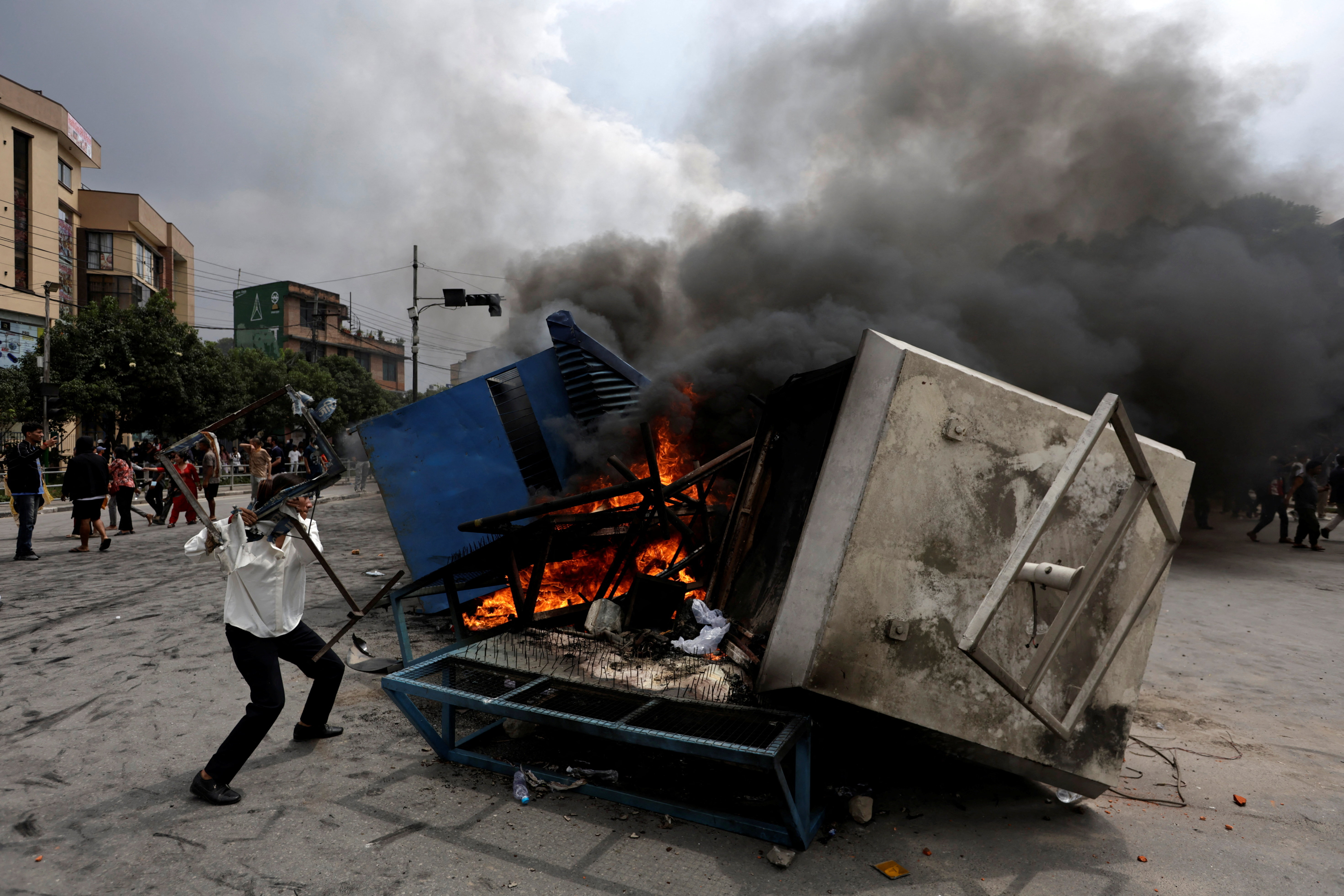 Demonstrators burn furniture and a police booth outside Nepali Congress party office, in Kathmandu
