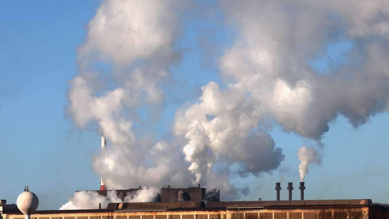 Smoke rises from chimneys at a factory in the port of Dunkirk
