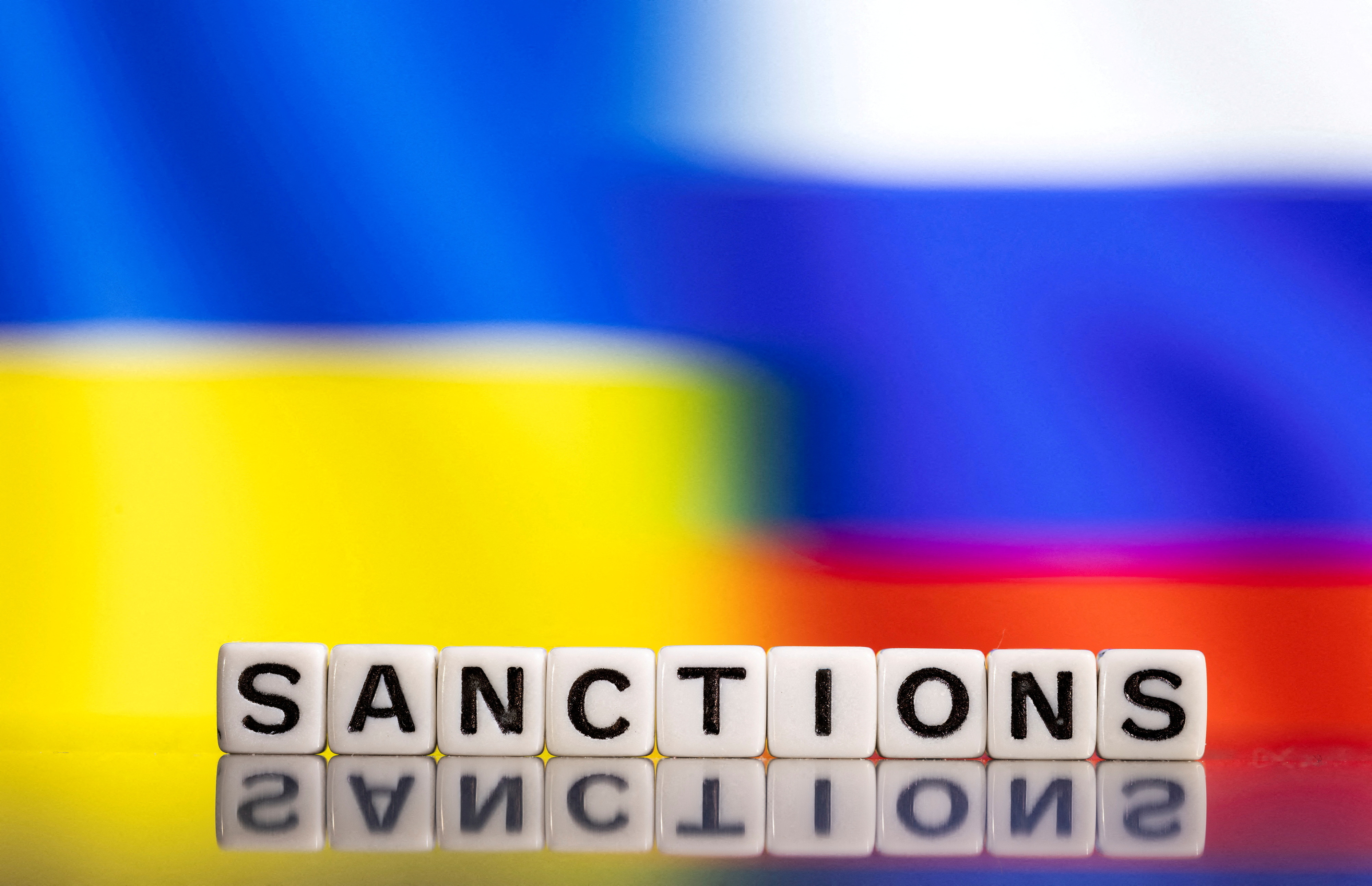 FILE PHOTO: Illustration shows letters arranged to read "Sanctions"  in front of Ukraine's and Russia's flag colors