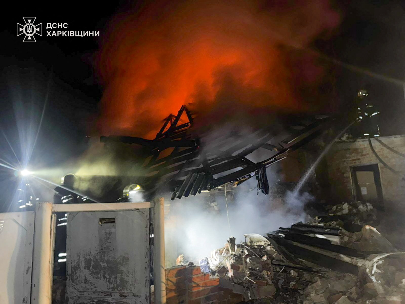 Firefighters work at the site of a house hit by a Russian drone strike in Kharkiv region