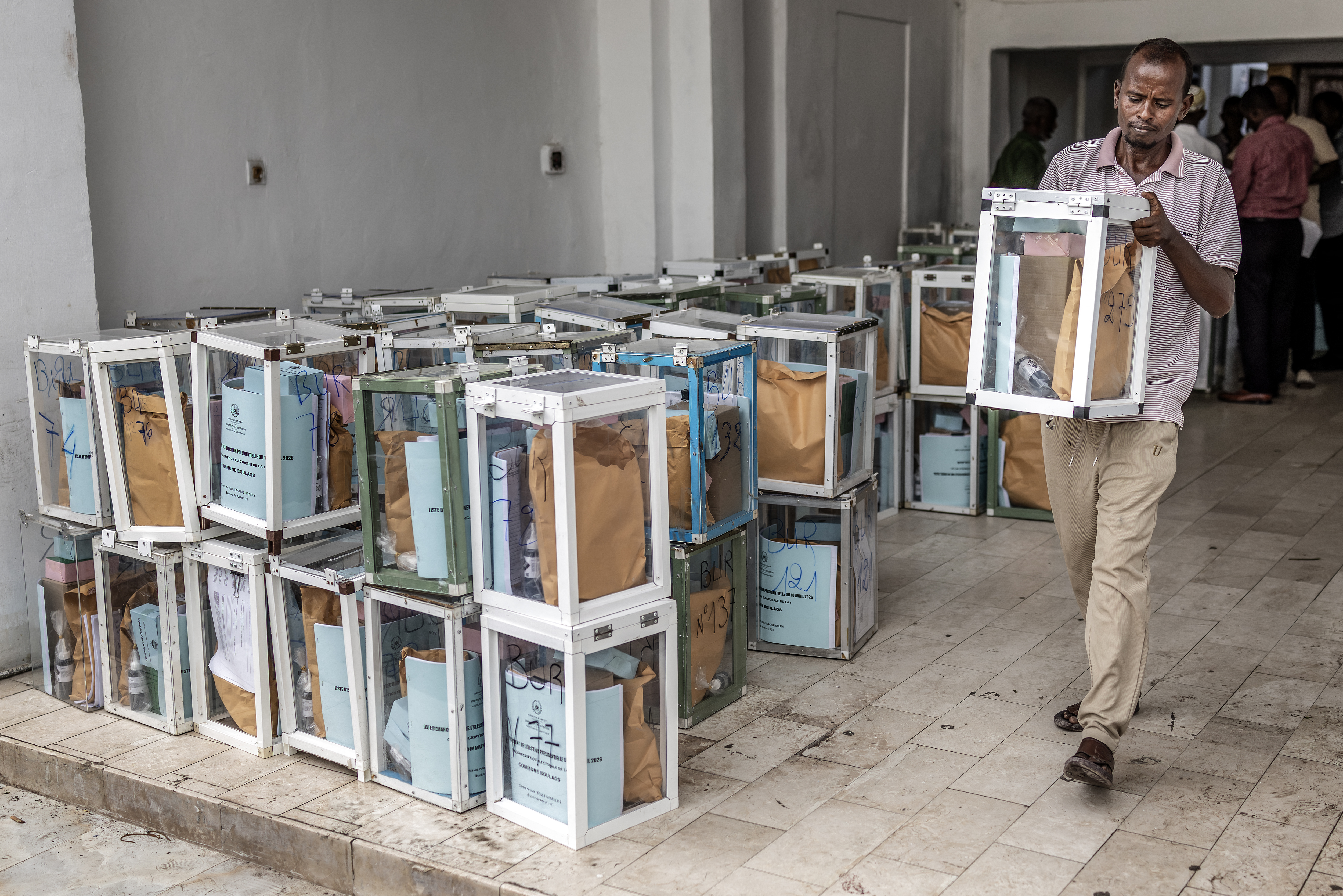 A worker carries a ballot box and electoral materials as they are dispatched to polling stations at City Hall in Djibouti, on April 9, 2026, ahead of the 2026 Djiboutian presidential elections. (Photo by Luis TATO / AFP)