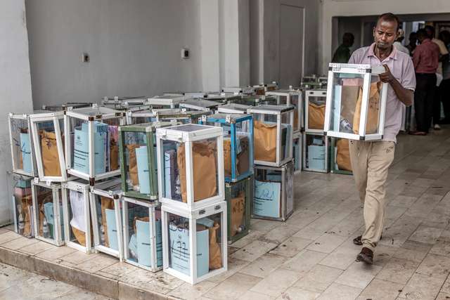 A worker carries a ballot box and electoral materials as they are dispatched to polling stations at City Hall in Djibouti, on April 9, 2026, ahead of the 2026 Djiboutian presidential elections. (Photo by Luis TATO / AFP)
