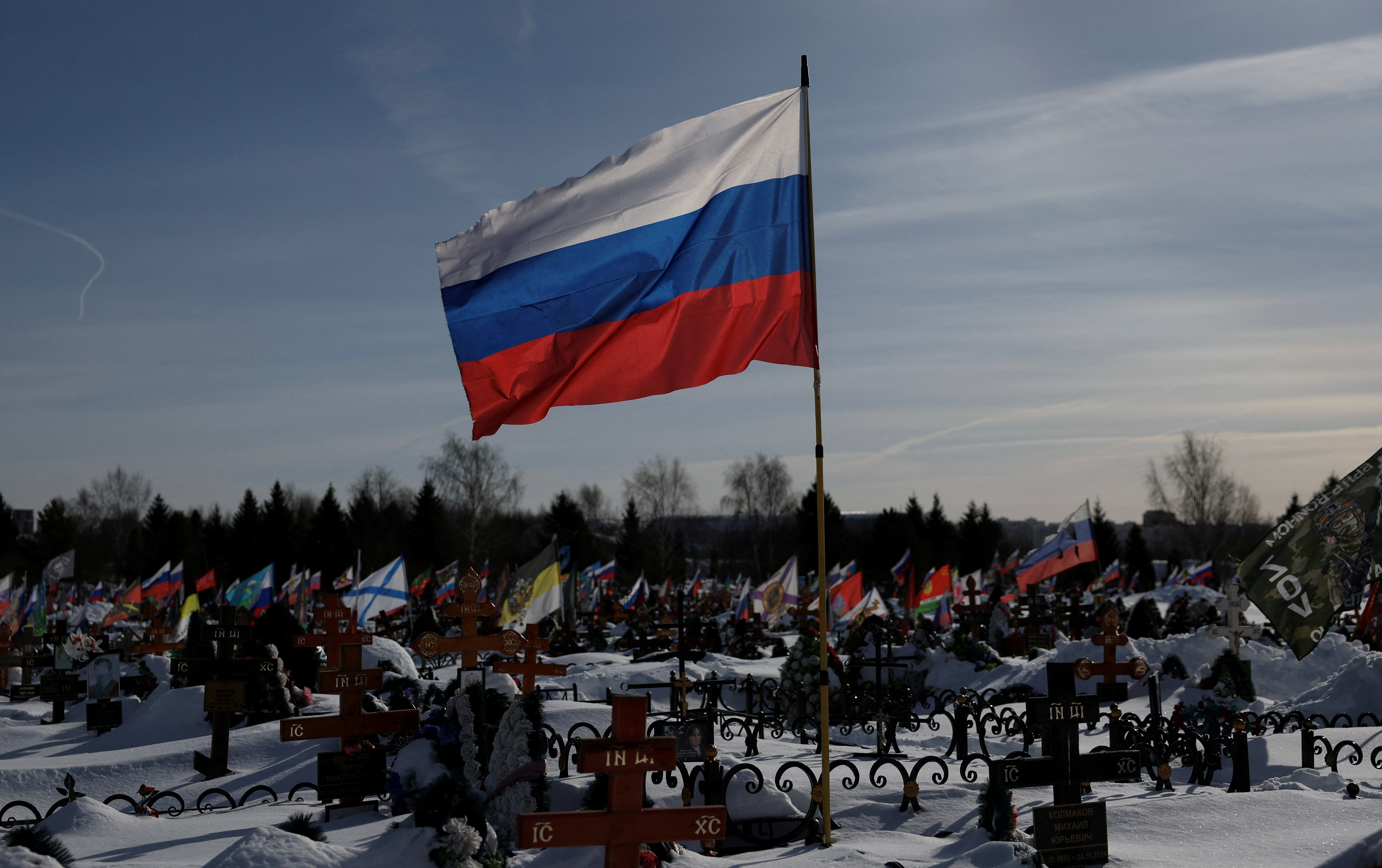 FILE PHOTO: Flags fly over the graves of Russian soldiers at a cemetery in Moscow region