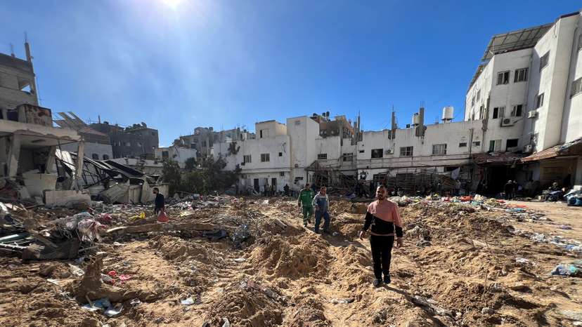 Palestinians inspect damages following an Israeli raid at Kamal Adwan hospital in the northern Gaza Strip