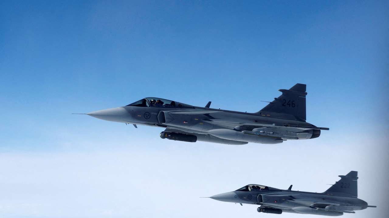 FILE PHOTO: Swedish Air Force Saab JAS 39 Gripen fighter jets fly alongside an aircraft simulating aerial interceptions during a media day