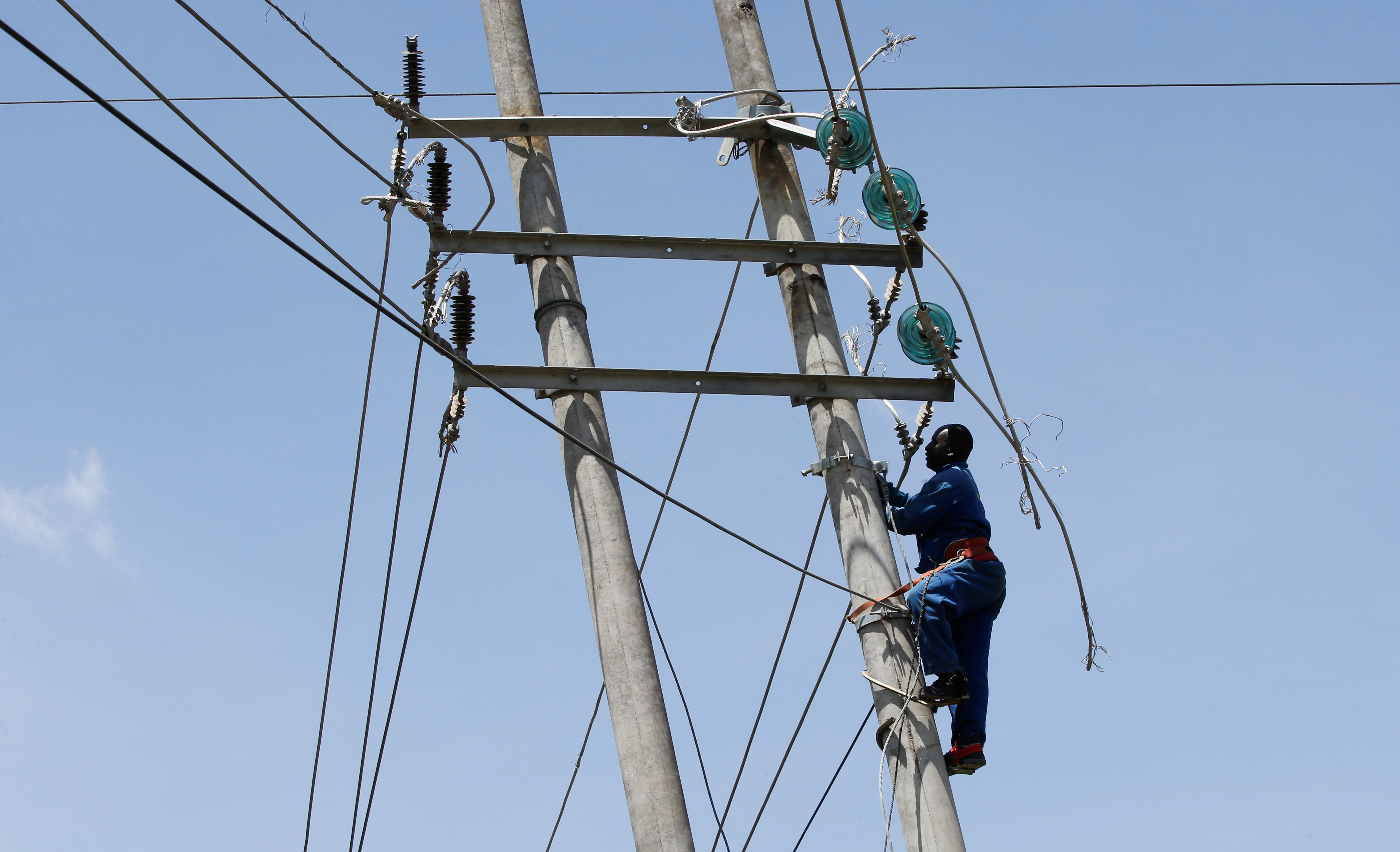 A technician works on the cables of a collapsed high voltage electricity transmission pylon from the Kiambere hydroelectric dam in Embakasi district of Nairobi
