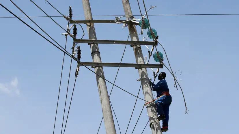 A technician works on the cables of a collapsed high voltage electricity transmission pylon from the Kiambere hydroelectric dam in Embakasi district of Nairobi