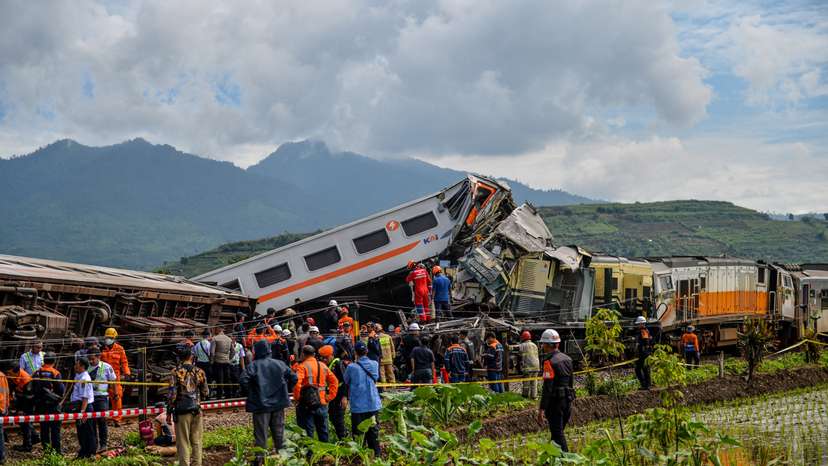 People stand at the site of a train collision between the local Bandung Raya train and the Turangga train in Cicalengka