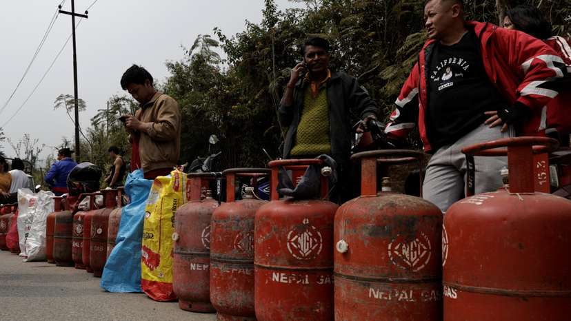 People stand in a queue with their empty LPG cylinders outside a depot of Nepal Gas Industries Pvt. Ltd. amid the U.S.-Israeli conflict with Iran, in Kathmandu