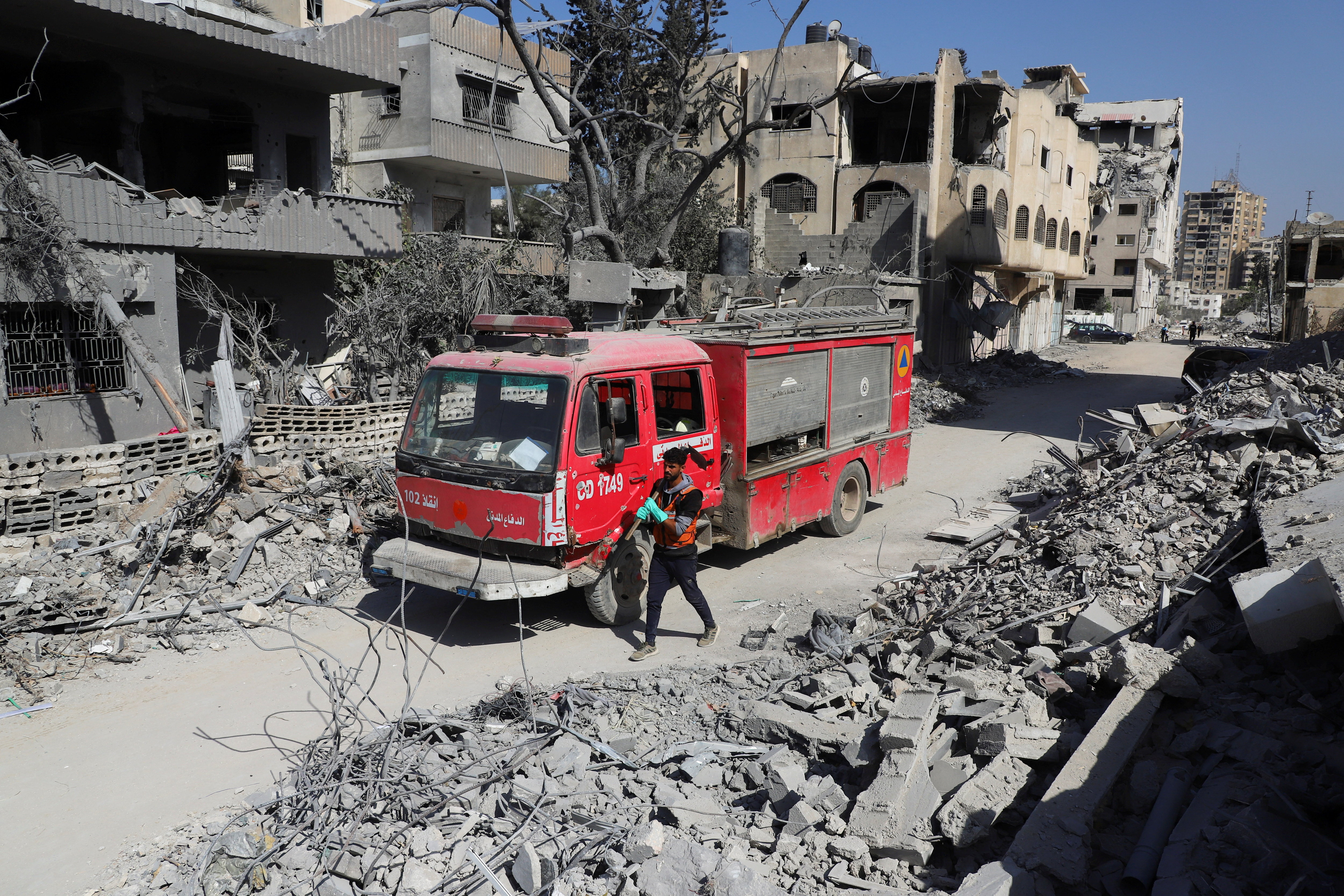 Palestinian Civil Defense search for bodies trapped under the rubble of destroyed buildings, in Gaza City