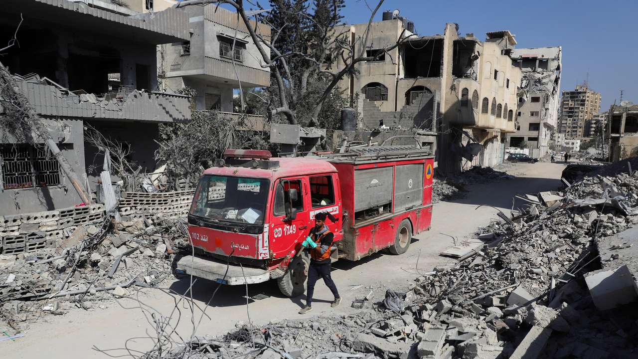 Palestinian Civil Defense search for bodies trapped under the rubble of destroyed buildings, in Gaza City