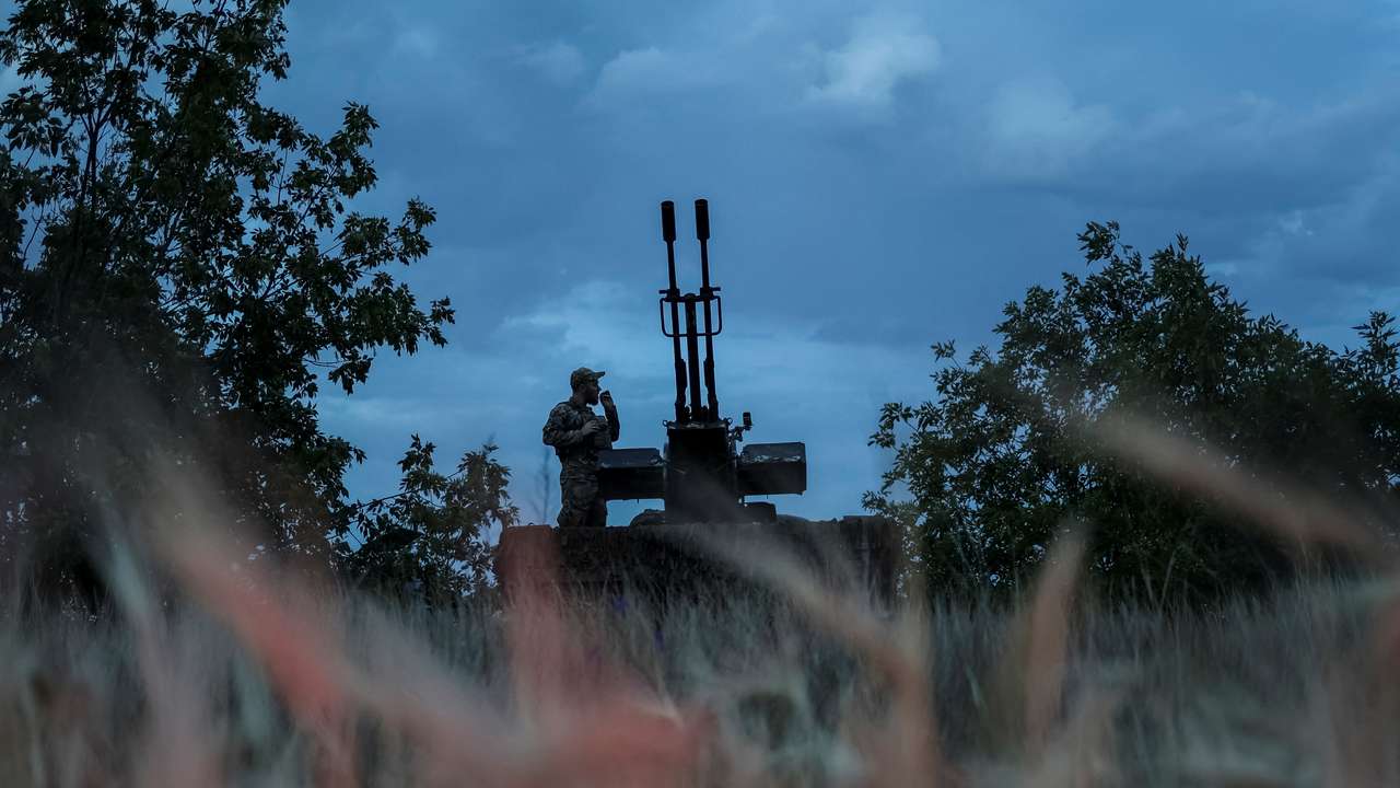 A Ukrainian serviceman from an anti-drone mobile air defence unit smokes near an anti aircraft cannon as he waits for Russian kamikaze drones in Kherson region