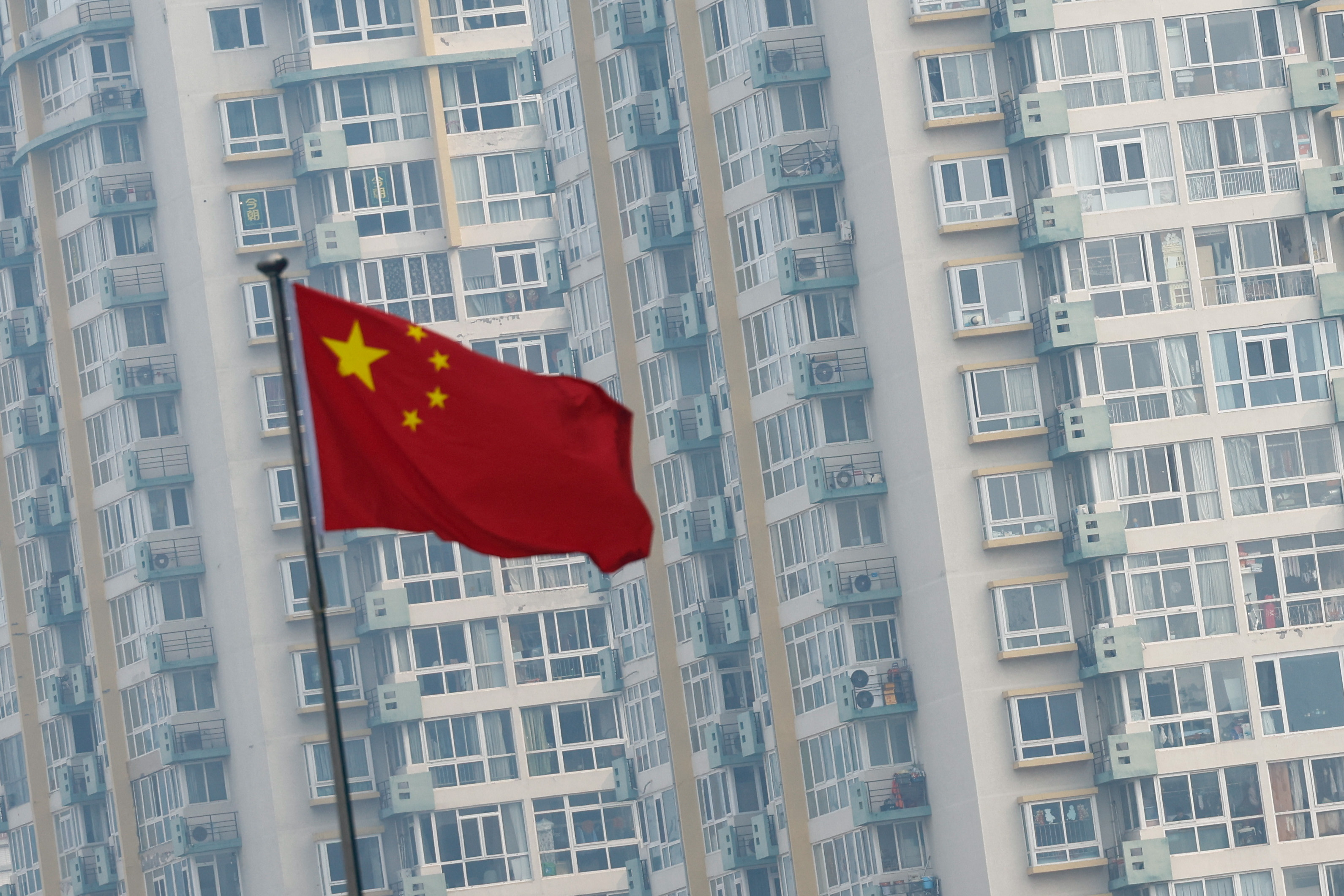 Chinese national flag flutters near residential buildings in Beijing