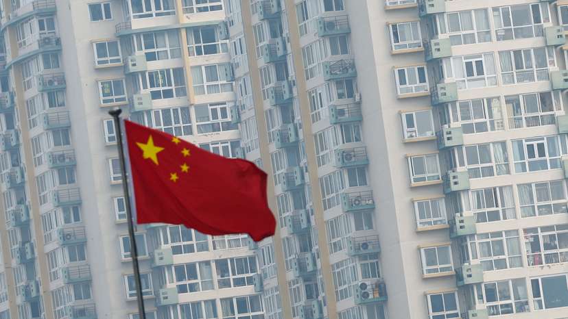 Chinese national flag flutters near residential buildings in Beijing