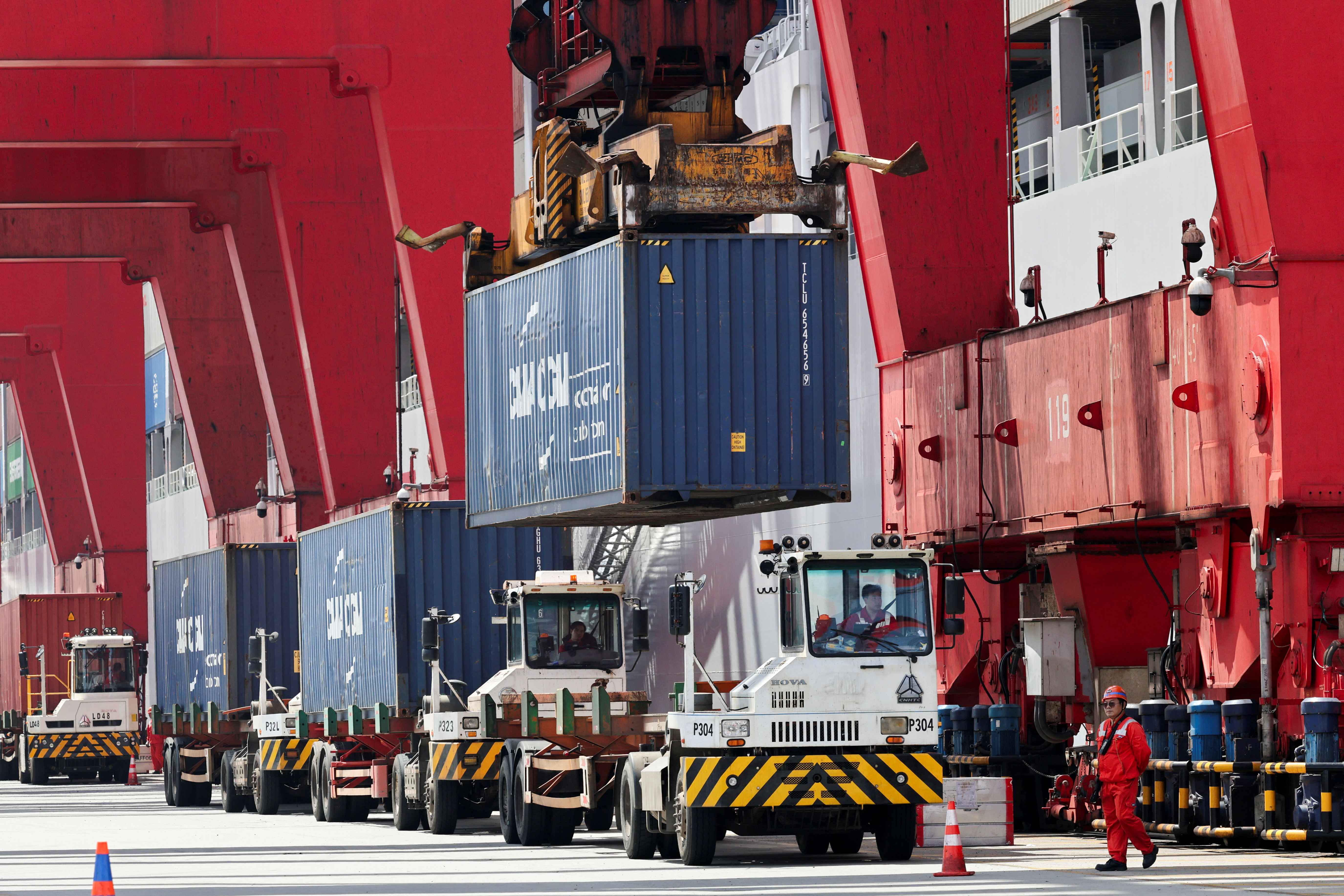 Container transporter trucks line up to be unloaded by gantry cranes at Yangshan Port outside of Shanghai