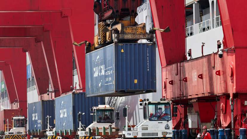 Container transporter trucks line up to be unloaded by gantry cranes at Yangshan Port outside of Shanghai