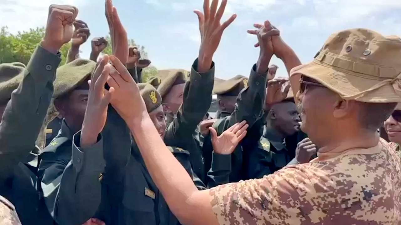 Head of Sudan's armed forces Abdel Fattah al-Burhan greets officers after drone strike hit army base, in Gebit
