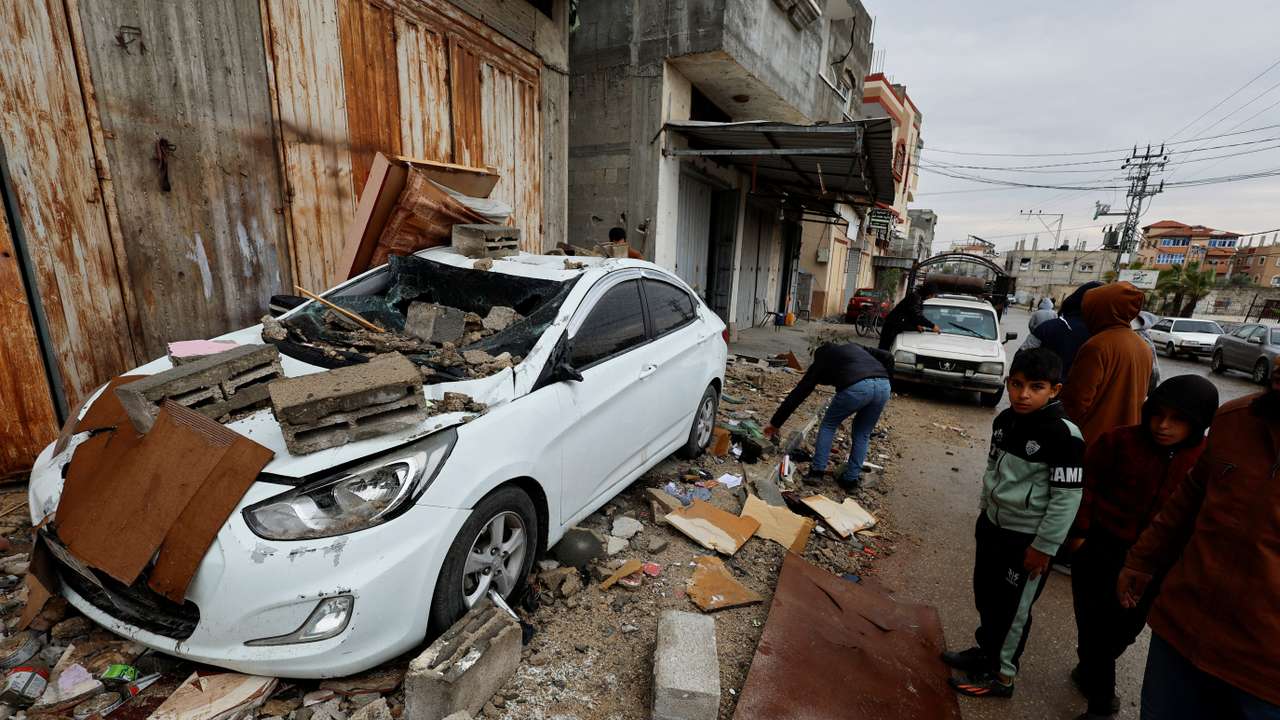 Palestinians inspect the site of an Israeli strike on a house in Rafah